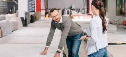 man showing woman a mattress